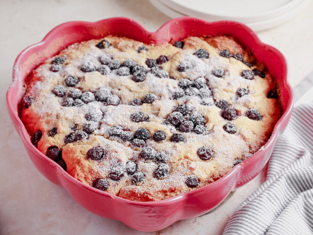 Blueberry Cake in a pink scalloped heart cake pan with icing sugar 