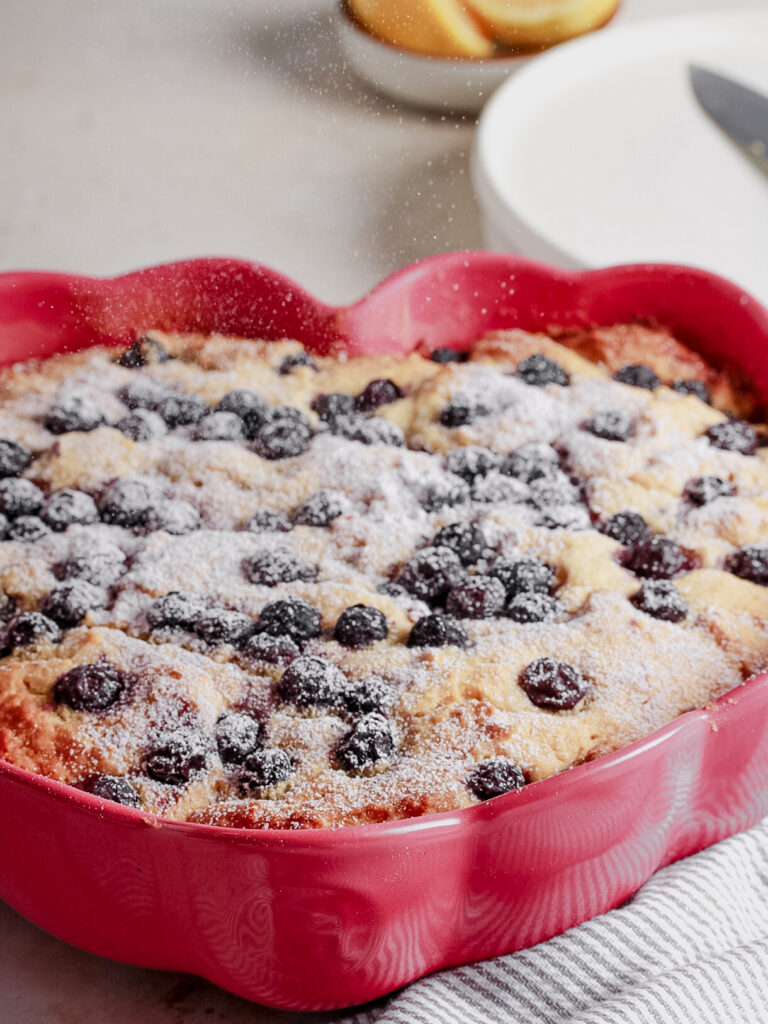 blueberry cake in pink heart baking pan with icing sugar on top