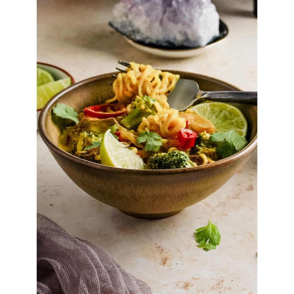 Yellow noodle bowl with lime and veggies